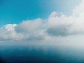 Naklejka na ściany i meble Blue sky with white clouds over calm summer panorama of the sea. Drone aerial view. Abstract aerial nature summer ocean sunset sea and sky background. Horizon. No people. Holiday and vacation concept