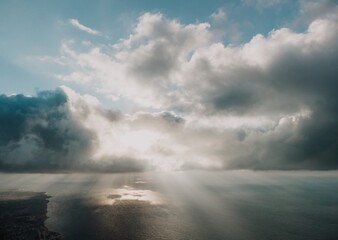 Fototapeta premium Aerial view. The drone flies over foggy and fluffy clouds. Blue sky sun and sea fog. Abstract aerial nature summer ocean sunset sea and sky background. Horizon. Vacation, travel and holiday concept