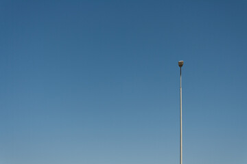 Fototapeta na wymiar a lonely lamppost against the blue sky, a place to copy
