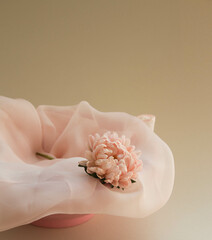 One aster flower on the silk scarf on beige neutral background. Elegant arrangement with pink flower.