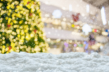 Empty white snow with blur Christmas tree with bokeh light background
