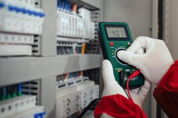 Electricity and electrical maintenance service, Engineer hand holding AC voltmeter checking electric current voltage.