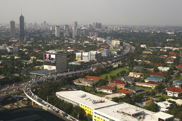 View of EDSA highway with residential houses, trees and buildings in the distance