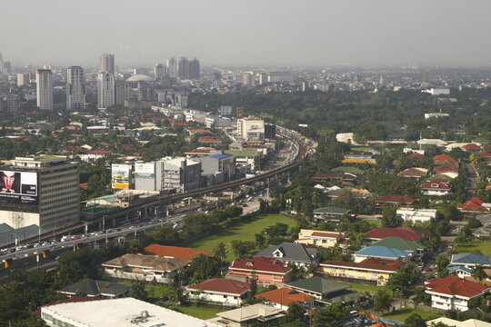 View of EDSA highway with residential houses, trees and buildings in the distance