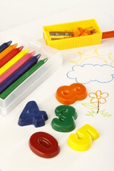 School materials on top of a child's colorful drawing