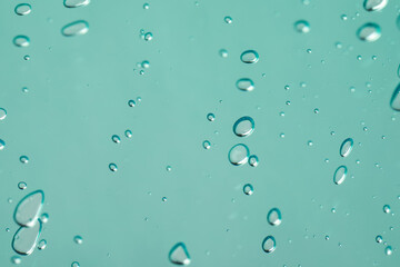 Serum drops on light blue background, closeup