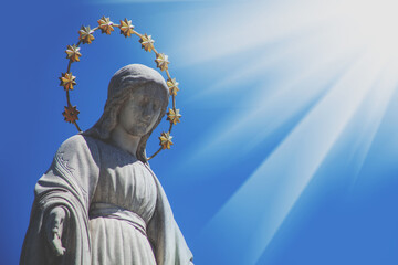Obraz premium Virgin Mary against blue sky. Fragment of ancient statue. Religion, faith, Christianity concept.