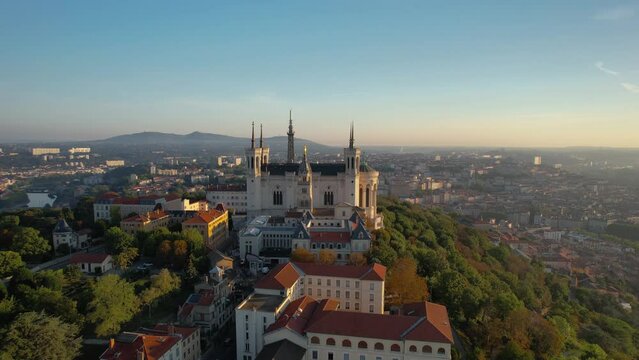 Drone aerial footage of spinning around of The Basilica of Notre-Dame de Fourvi&egrave;re and Metallic tower at sunrise in Lyon, France.