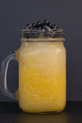 foreground cold fruit juices or ice cream in glass jars and tapioca pearls pineapple and melon smoothie with dark background and blackboard table 
