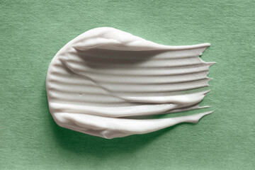 Natural cosmetic cream or balm. Swatch on green crafted paper.