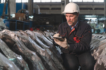 Senior engineer use tablet checking spares in factory spares train	