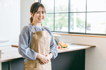 キッチンに立つ主婦・家政婦・家事代行・調理師のアジア人女性
