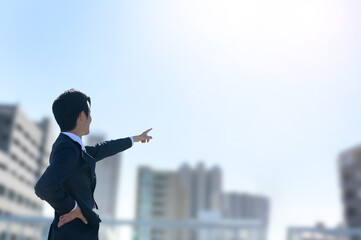 目標を指さすカッコイイサラリーマンの男性