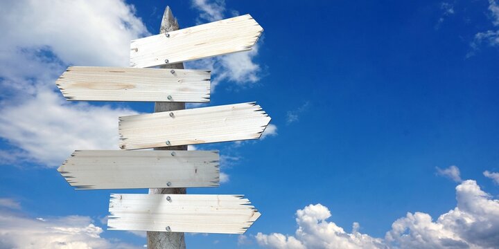 Naklejki Wooden signpost with five clear arrows