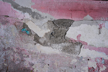 Old concrete wall with chipped plaster pieces and black mold background texture