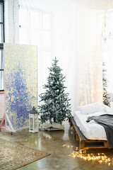 Christmas decorated bright bedroom interior with comfortable bed and Christmas fir trees. Cozy home moment, Happy New Year and Christmas morning concept