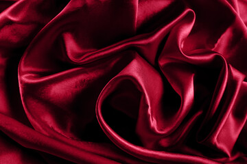 Trendy color viva magenta smooth silk background. Elegant bright satin with waves. Fabric backdrop, view from above. Luxury cloth texture. Prefect as an abstract background with copy space, close-up.