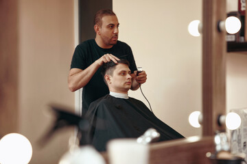 Barber shaving caucasian man in barber shop