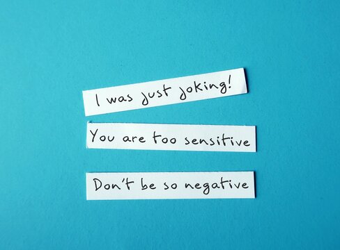 On Blue Background, Torn Paper With Handwriting I WAS JUST JOKING, YOU'RE SO SENSITIVE And DON'T BE SO NEGATIVE, Gaslighting Verbal Abuse Use To Manipulate And Pin Whole Blame To Victim