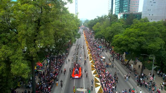 aerial drone shot during the day of the dead parade in mexico city with the passing of floats with flowers