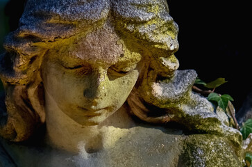 Fototapeta na wymiar Close up of an ancient statue of guardian angel (vintage style photo)