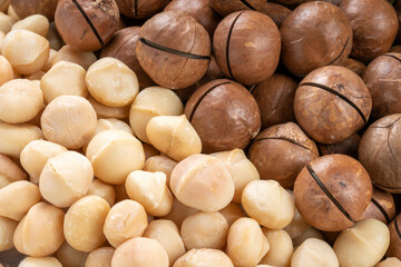 Macadamia nuts and Macadamia with hard shell on wooden background.
