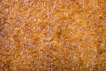 
Almond slices baked in caramel, top view, background.