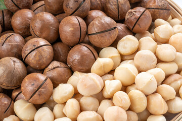 Macadamia nuts and Macadamia with hard shell on wooden background.