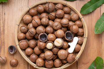 Macadamia nuts and Macadamia with hard shell on wooden background.