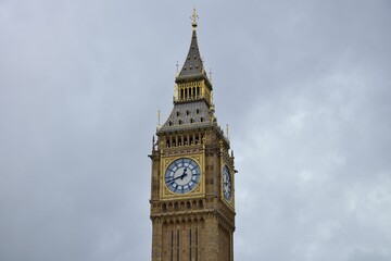Closeup shot of the top of the Big Ben tower against the background of gloomy clouds