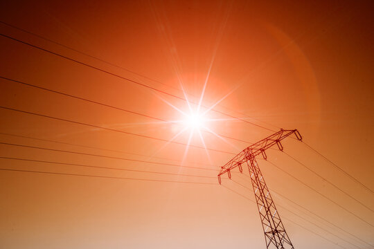scorching summer sun on red sky and power line wires