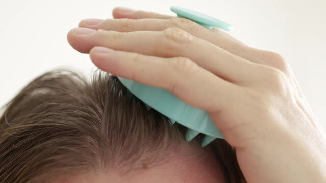 Close up of using scalp massaging brush with long hair, hair growing routine.