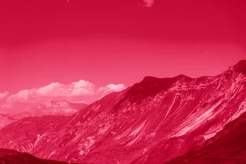 Beautiful sunny day in mountain valley and mountainous countryside landscape in summer. Image toned in color of year 2023 Viva Magenta. Mountain range under cloud sky.