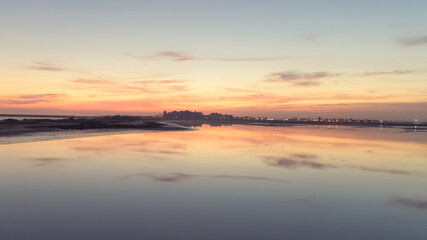 sunset on the beach with water and golden sky