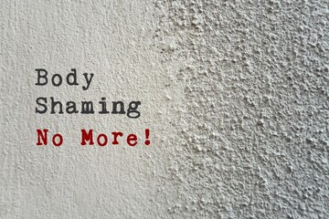 Grey cement concrete rough texture wall background with text BODY SHAMING NO MORE , stop...