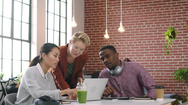 Laptop, creative team and brainstorm for idea in marketing agency with online analysis in office. Pc, data and businesspeople or digital marketing team discuss strategy with diverse teamwork