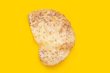 Crispy taro chip on yellow background.