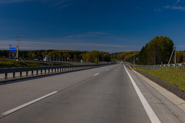 Fototapeta premium Highway wide road, transport and blue sky with clouds on a summer day