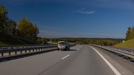 Naklejka premium Highway wide road, transport and blue sky with clouds on a summer day