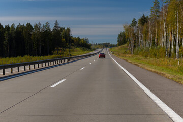 Fototapeta premium Highway wide road, transport and blue sky with clouds on a summer day