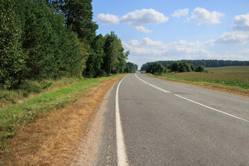 Naklejka premium Highway wide road, transport and blue sky with clouds on a summer day