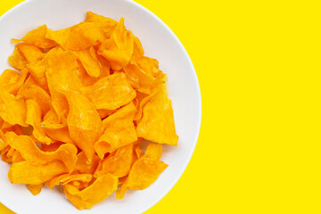 Sweet potato chips on yellow background.