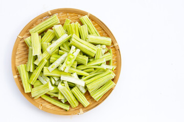 Moringa oleifera cut in pieces in bamboo weave plate on white background.