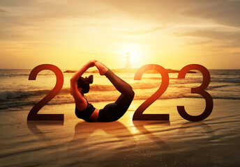 Happy new year card 2023. Silhouette of healthy girl doing Yoga One Legged Pigeon pose on tropical...