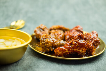 Deep fried chicken wing with garlic sauce and spicy sauce in Korean style served with pickled radish, Asian food concept.
