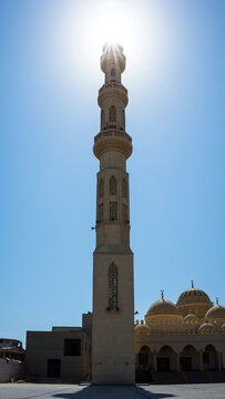 El Mina Masjid Mosque in Hurghada, in shadow of minaret with sun rays behind, Egypt architecture
