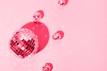  Beautiful disco balls on a pink background. Modern postcard with space for text. Image toned in the color of the year 2023