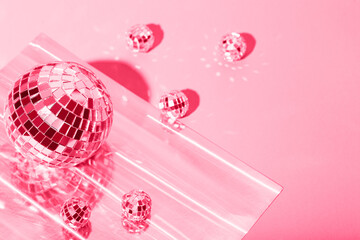  Beautiful disco balls on a pink background. Modern postcard with space for text. Image toned in the color of the year 2023