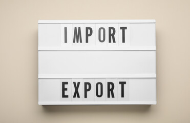 Lightbox with words Import and Export on beige background, top view