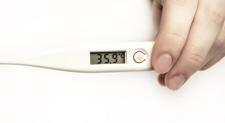 Electronic modern thermometer in hand on a white background. Thermometer. Medicine, pharmacy concept